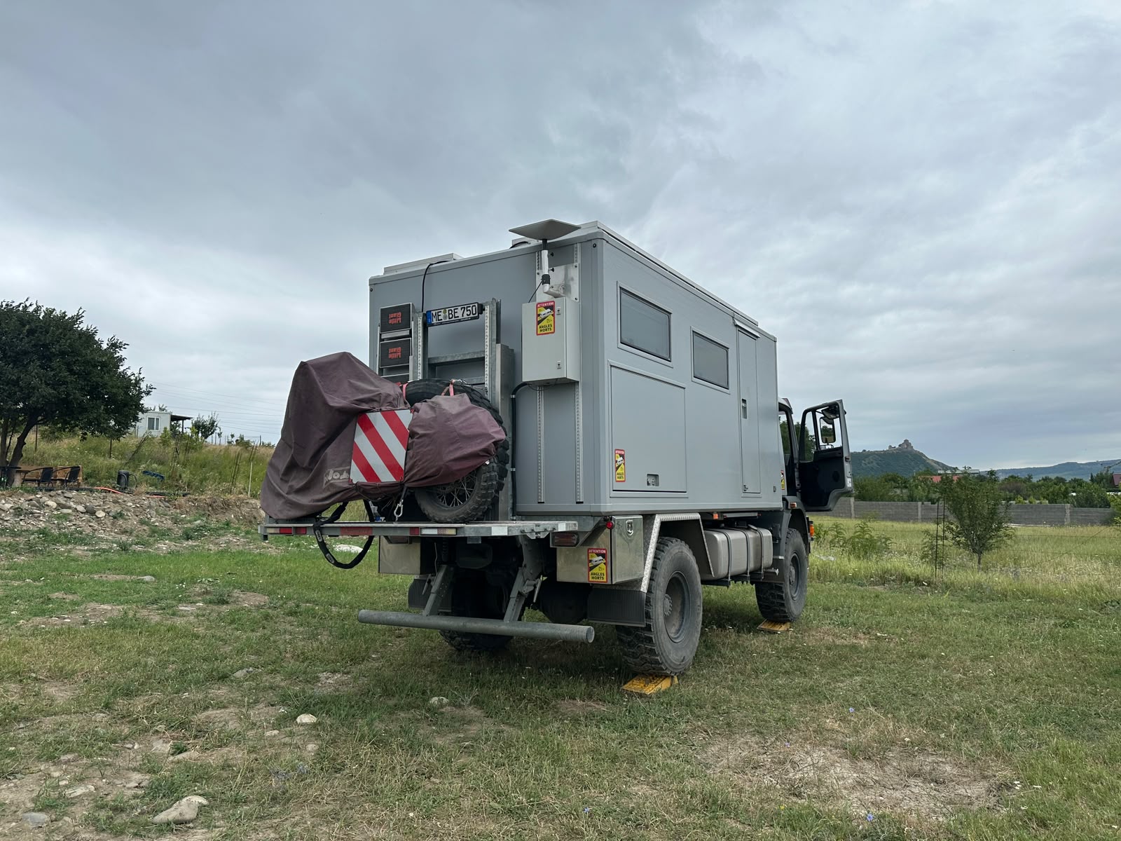 Large grey expedition truck parked on the grass