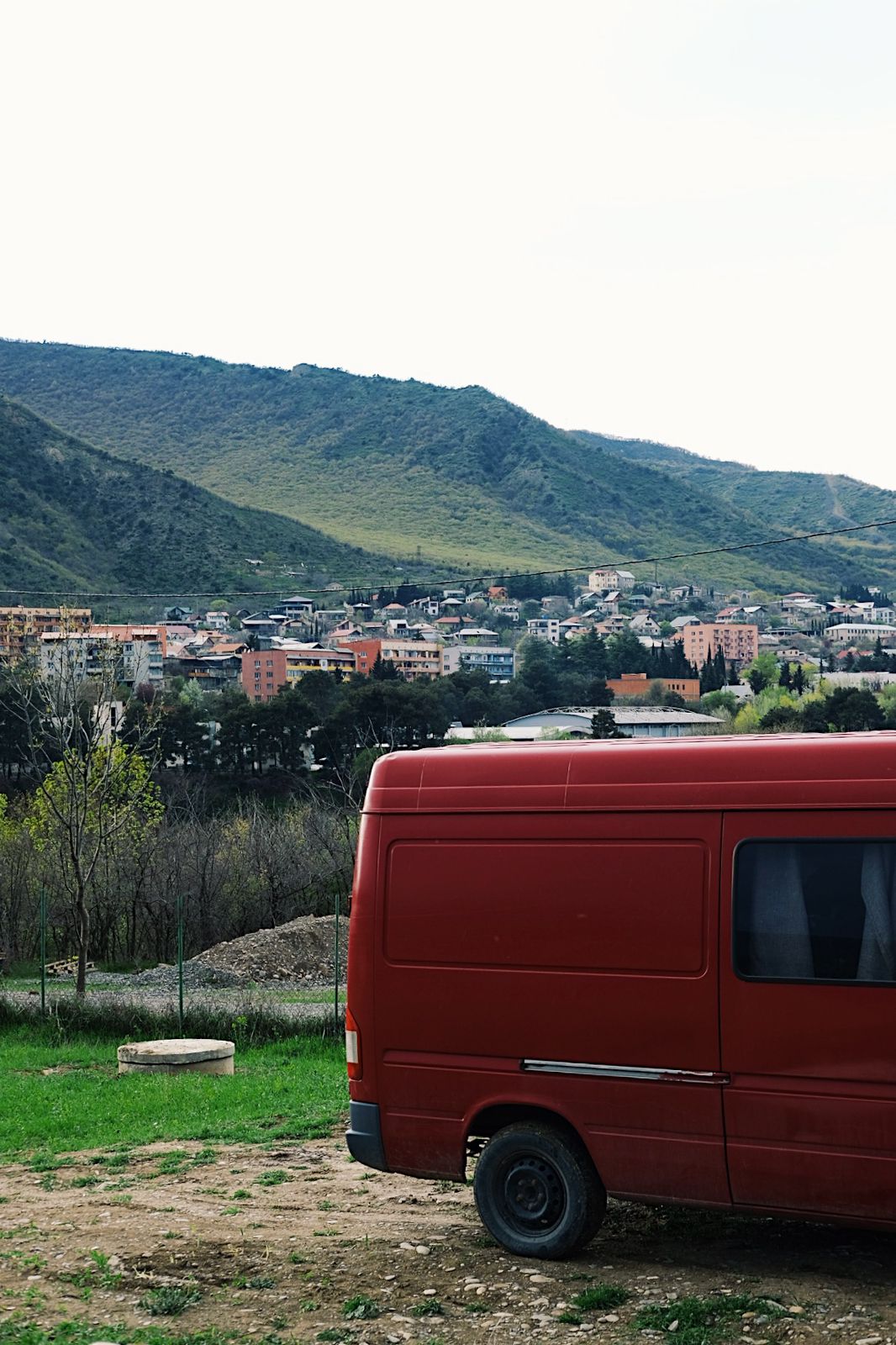 Red campervan parked on a pitch above the town